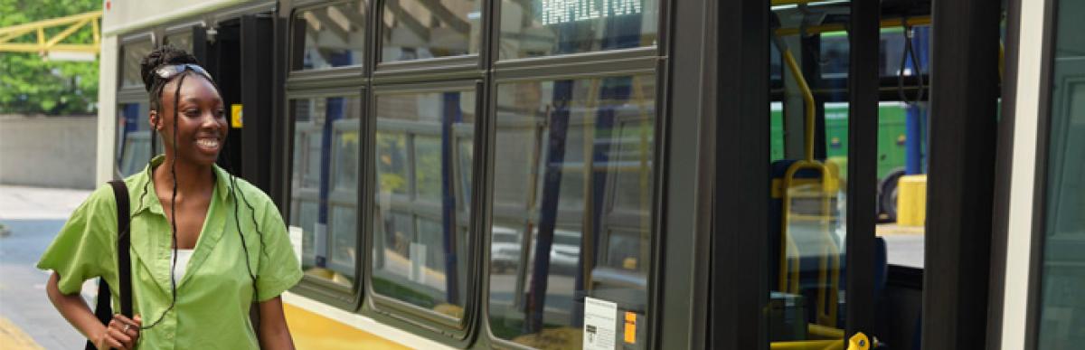 woman standing next to a opened door bus