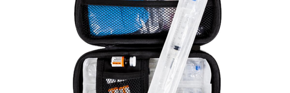 open naloxone kit showing contents (syringe, rubber gloves, naloxone vials)