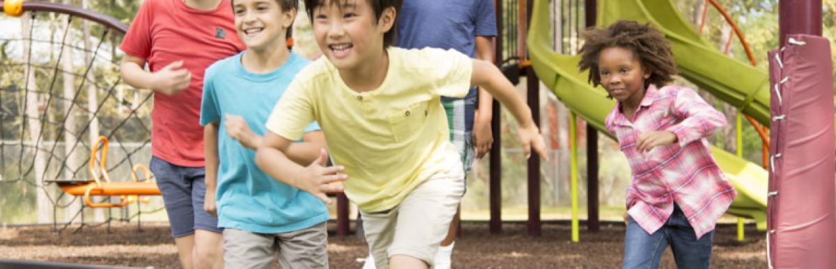 Five children running and playing at a playground