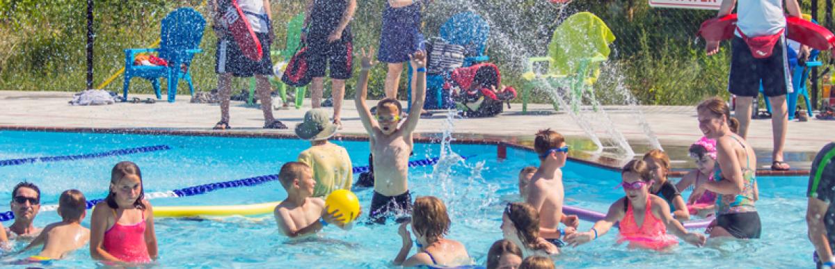 Lots of people swimming and splashing in an outdoor city pool
