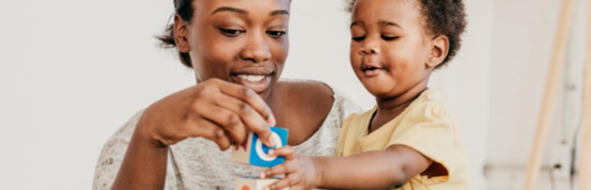 mother with toddler playing with letter blocks