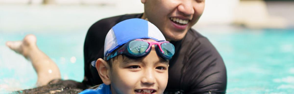 Man and boy swimming in an indoor pool