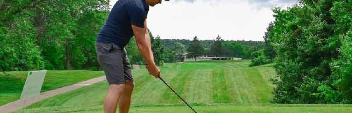 Man about to hit a golf ball on a golf course