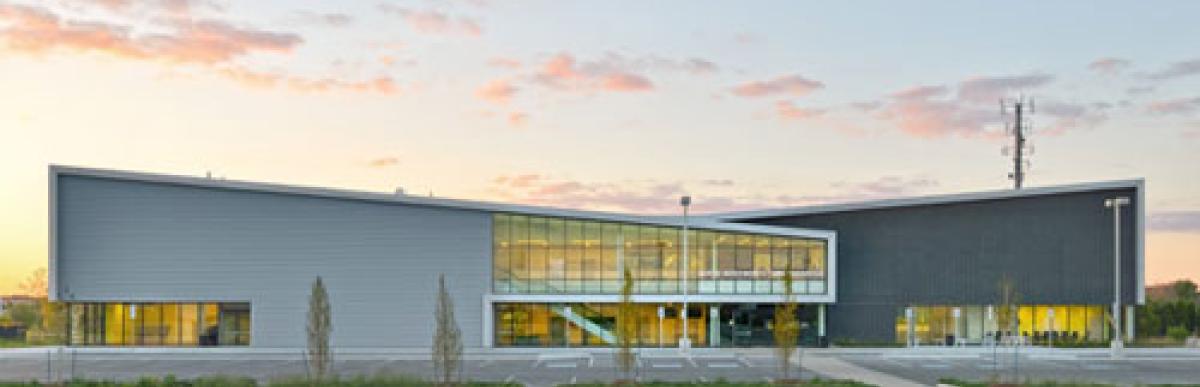 Exterior of Harry Howell Twin Pad Arena from the parking lot with the sun setting behind the building