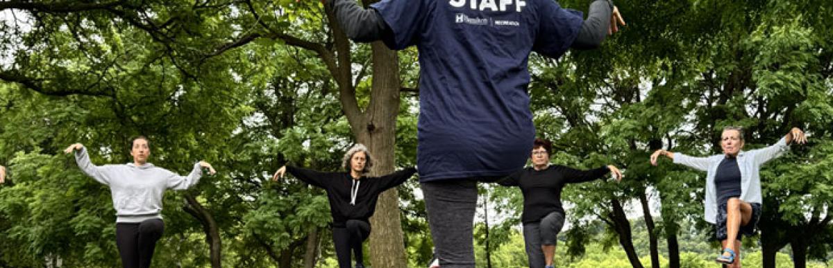 People in yoga poses outdoors in a park setting