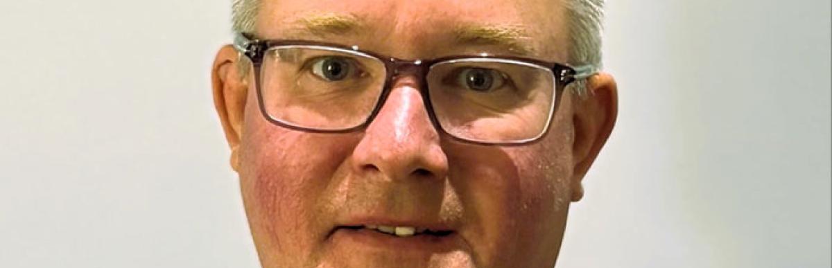 Head and shoulders of Brian Hollingworth, middle-aged white male with glasses and short greying hair