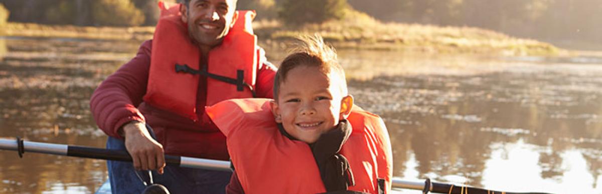 Father and son wearing lifejackets in a kayak