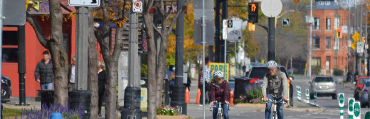 two cyclists in a bike lane on Bay St in Hamilton on a fall day
