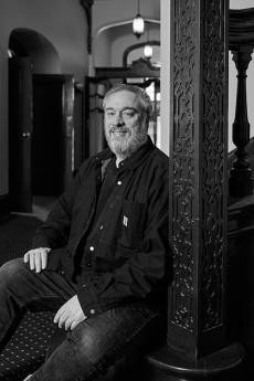 man sitting leaning against post