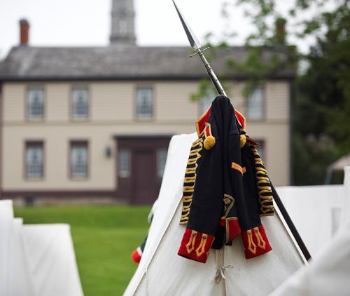 Re-enactment Period Coat and weapon leaning on canvas tent