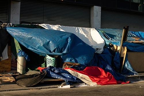 A homeless encampment sits on a street in a downtown area