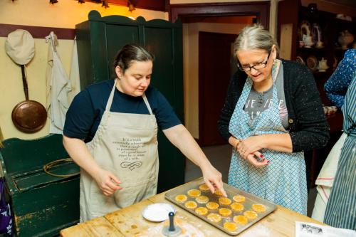Two women baking pastries at a historic workshop