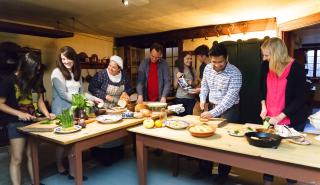 People gathered cooking in a kitchen