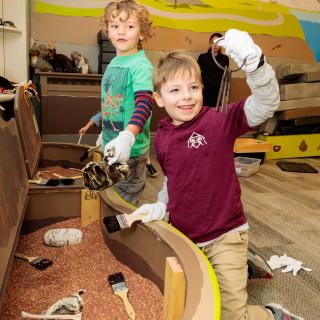 children digging items out of a sandbox