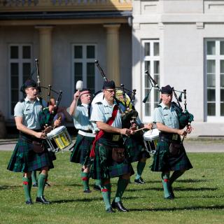 Military regiment in quilts playing bagpipes