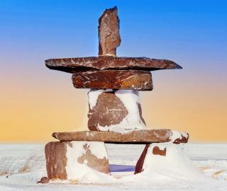 partially snow covered inukshuk