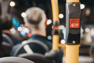 image of the request stop button on a bus at night