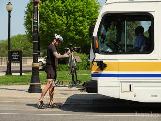 bike rider putting bike on bus rack